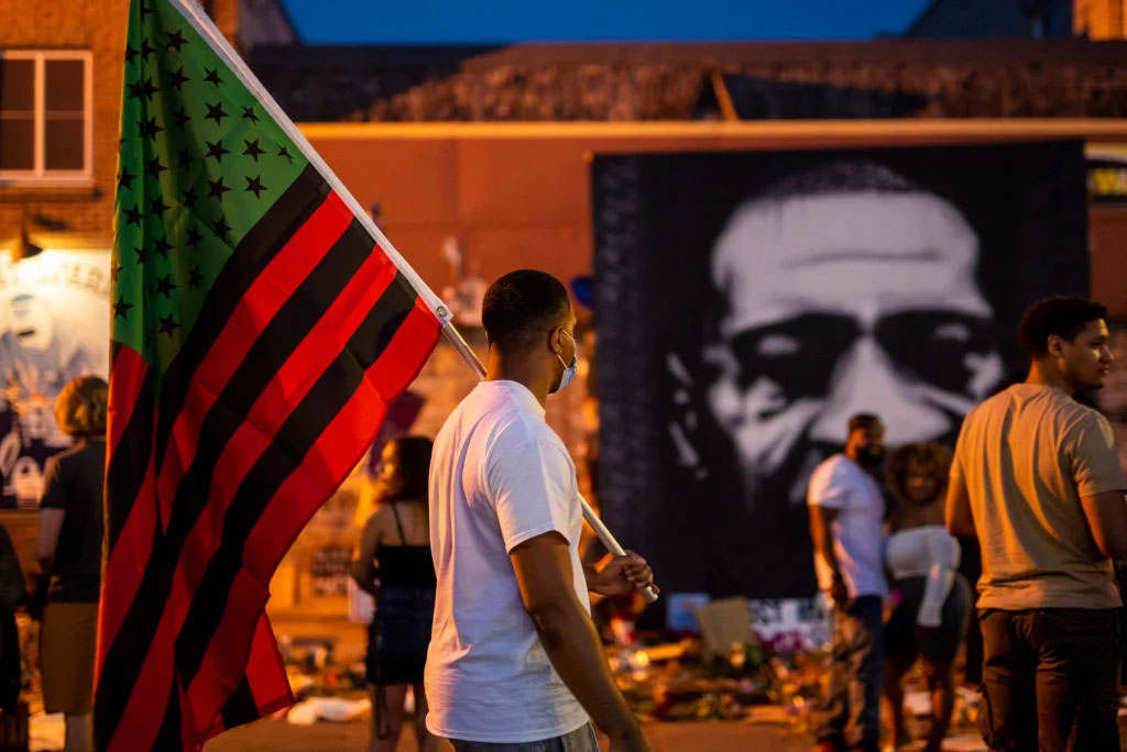 A man carries a Black Liberation flag through a Juneteenth celebration at the memorial for George Floyd outside Cup Foods on June 19, 2020, in Minneapolis. (Stephen Maturen&mdash;Getty Images)